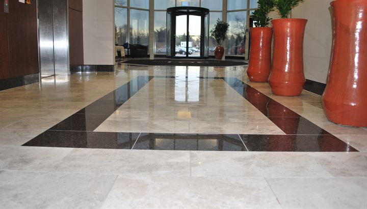 Polished marble lobby floor framed by a dark stone border