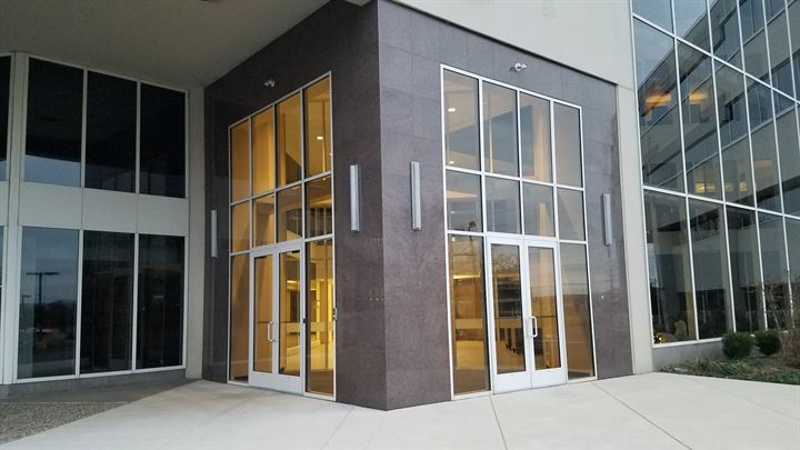 Commercial building entrance with glass doors and dark panel cladding