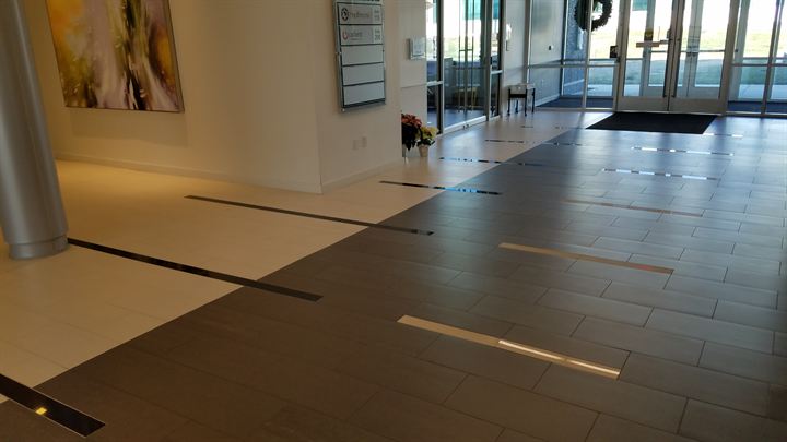 Entry corridor with contrasting light and dark tile bands