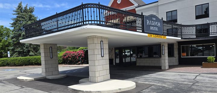 Hotel porte-cochère with columns clad in large-format panels laid in an ashlar block pattern