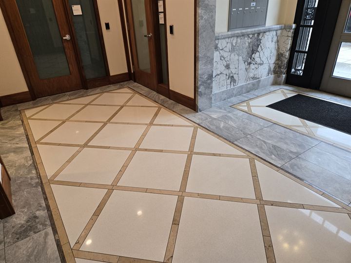 Marble vestibule floor with a diagonal lattice inlay, gray marble border and book-matched marble wainscot