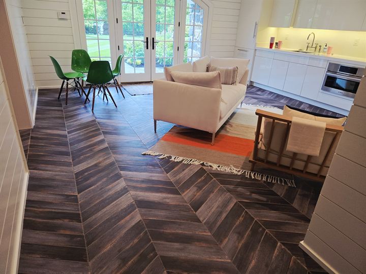 Lounge with dark wood-look porcelain tile laid in a chevron pattern