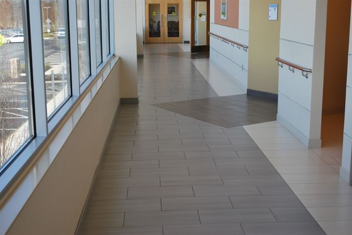 Window-lined corridor with an inset tile rug pattern