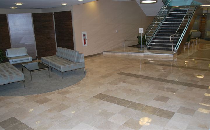 Polished stone lobby floor with seating and a feature staircase